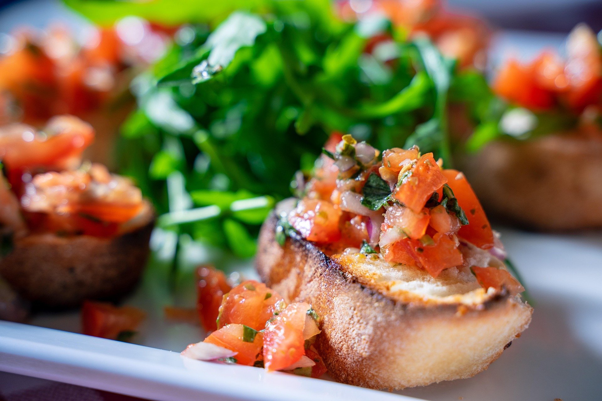 Toasted bread topped with tomato salsa, served with a greens salad