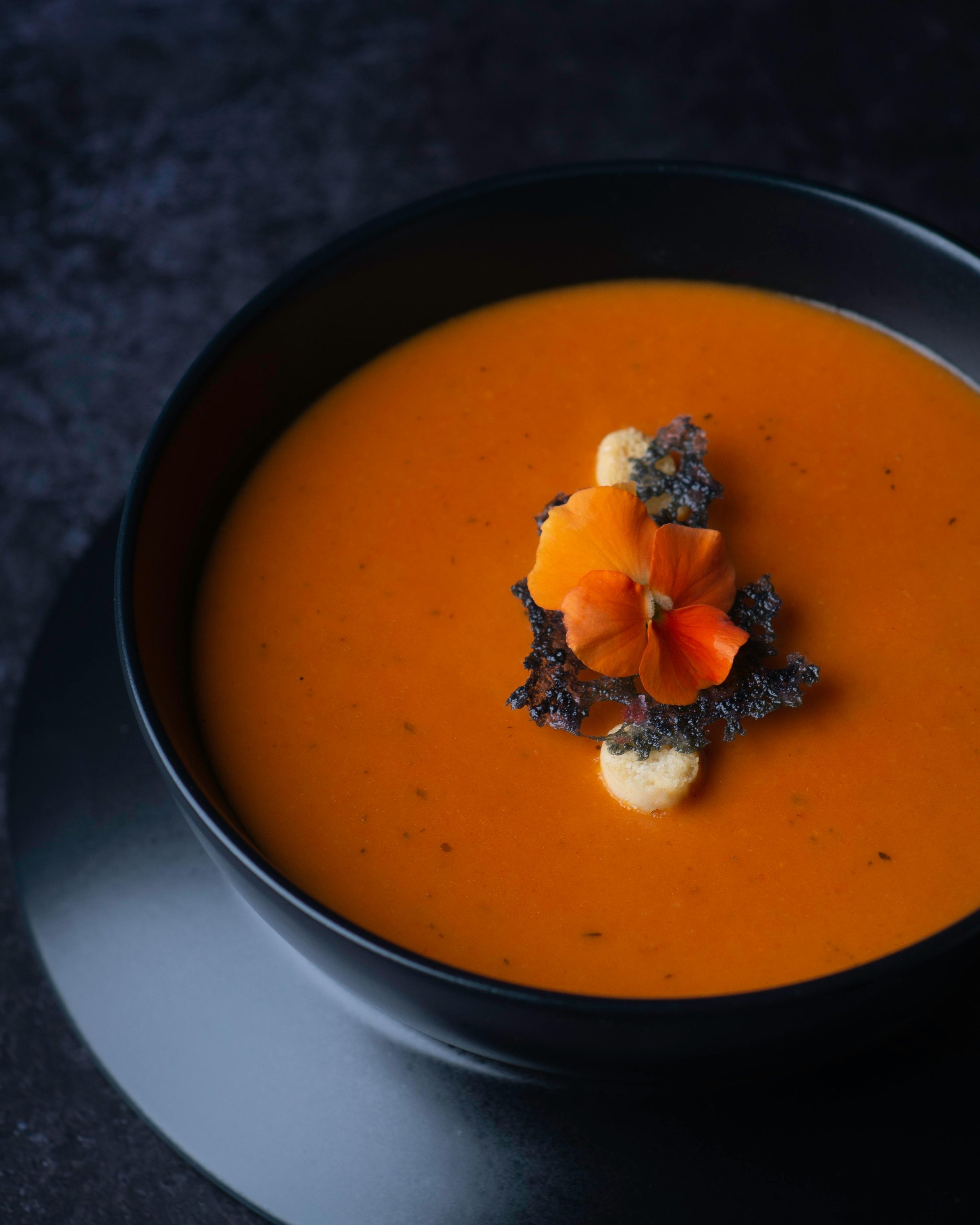 Soup bowl, garnished with edible flowers.
