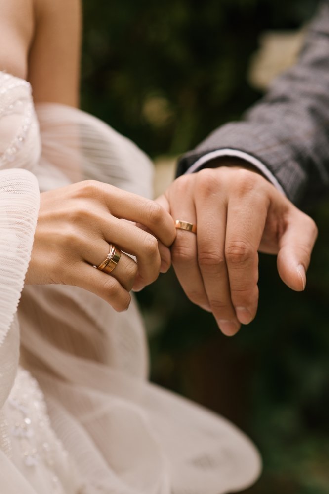 Couple holding hands with wedding bands